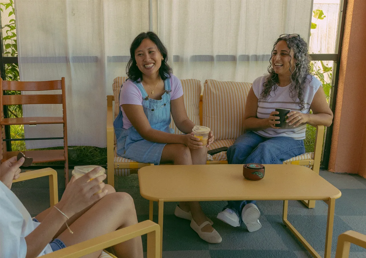 Friends laughing together over coffee around a table
